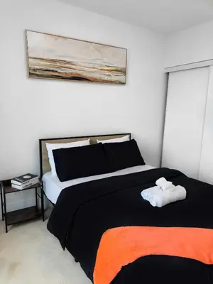 a bedroom with a black and orange bed and a painting at Modern One Bedroom Near Square One With Free Parking in Mississauga