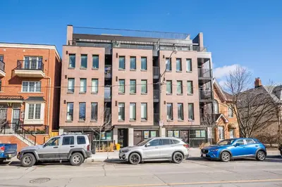 three cars parked in a parking lot in front of a building at Inviting 2BR Basement Suite in Downtown Toronto - The Roland in Toronto