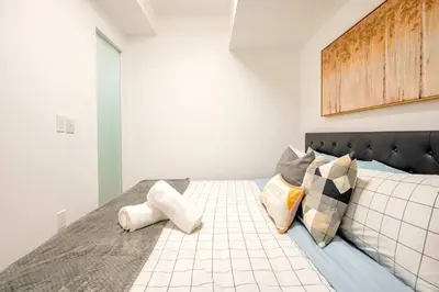 a bedroom with a bed with pillows on it at Peaceful 2BR Basement Suite Near Downtown Toronto - The Roland in Toronto