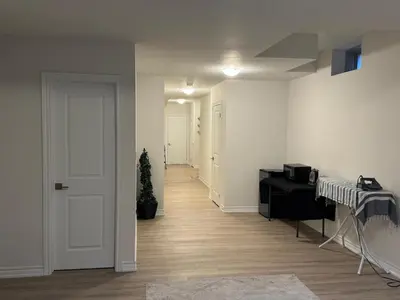 an empty room with a white door and a plant at Modern Luxury Basement Suite in Oakville