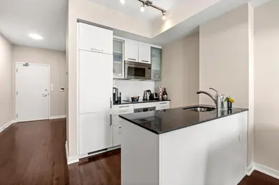 a kitchen with white cabinets and a black counter top at Luxury Lakeview Downtown Condo, CN Tower, Rogers Center, Scotia Arena, Lake View with Free Parking in Toronto