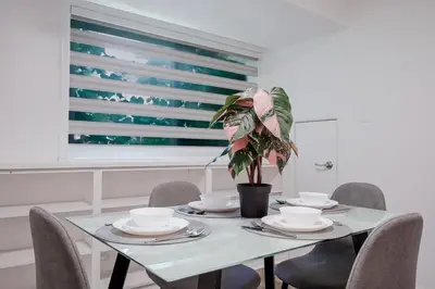 a dining room table with chairs and a potted plant at 2 Bed 2 Bath Bunglow in Mississauga Yyz PortCredit in Mississauga