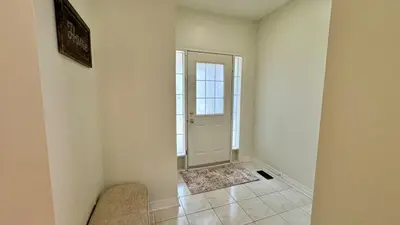 an empty hallway with a white door and a chair at Spacious 4BD Oasis with Sauna in Mississauga