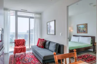 a living room with a couch and a bed at Downtown 1BR City Stay with Balcony and Fast Wi-Fi in Toronto