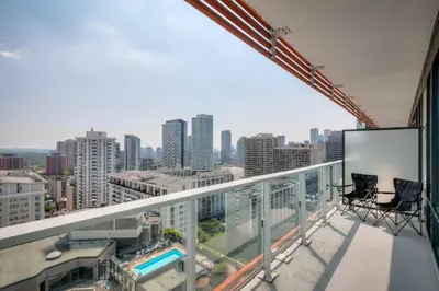 a balcony with two chairs and a view of a city at Downtown 1BR City Stay with Balcony and Fast Wi-Fi in Toronto