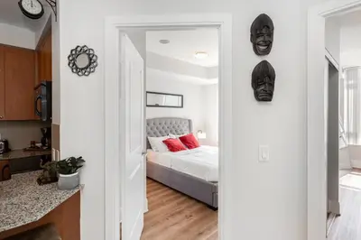 a bedroom with a bed with a mask on the wall at Lavish 2BR 2Bath Condo Steps to Square One Mall in Mississauga