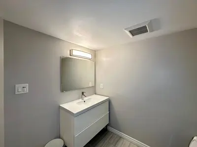 a white bathroom with a sink and a mirror at Mountain View House - Sleeps 14 in St. Catharines