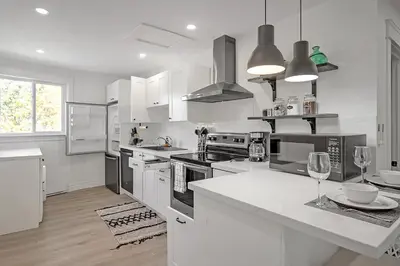 a kitchen with white cabinets and a white counter top at The Dove Loft Near DT & Hospital in Peterborough