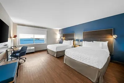 a hotel room with two beds and a desk at Tru By Hilton Oshawa in Oshawa