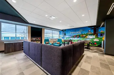 a restaurant with a waiting area with blue chairs at Tru By Hilton Oshawa in Oshawa
