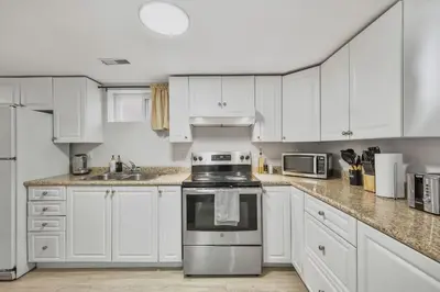 a kitchen with white cabinets and a stove top oven at Comfy 2BR Apt near Beach and Downtown Free Parking in Oshawa