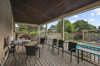a deck with a pool and chairs and a table at Mins to Beach Downtown 5BR w Pool Patio and BBQ in Cobourg
