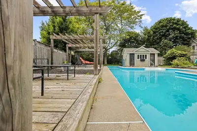 a swimming pool with a wooden pergola next to a house at Mins to Beach Downtown 5BR w Pool Patio and BBQ in Cobourg