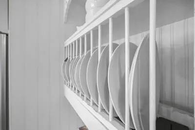 a row of white plates on a wall at Mins to Beach Downtown 5BR w Pool Patio and BBQ in Cobourg