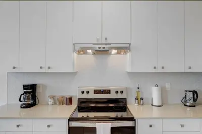 a kitchen with white cabinets and a stove top oven at Stylish 3BDR in Pickering Heart Free Parking in Pickering