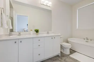 a white bathroom with two sinks and a tub and a toilet at Stylish 3BDR in Pickering Heart Free Parking in Pickering