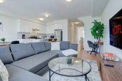 a living room with a blue couch and a glass table at Stylish 3BDR in Pickering Heart Free Parking in Pickering