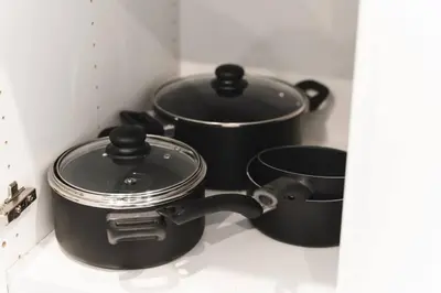 three pots and pans on a stove in a kitchen at Waterfront Bliss Firepit and BBQ in Hanover
