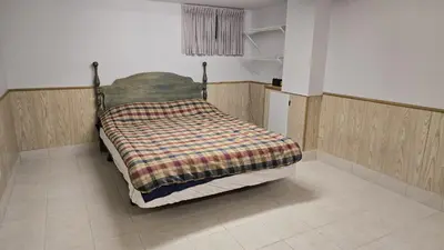 a bed with a blanket on it in a room at Spacious, Peaceful & Perfectly Located - 4BR,3BA in London