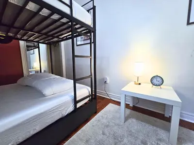 a bedroom with two bunk beds and a table with a lamp at 80's Retro Toronto Time Capsule - 2 Bedrooms in Toronto