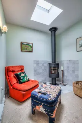 a living room with a red chair and a stove at Cozy 2BR Home with Workspaces, Fireplace and Parking in Toronto