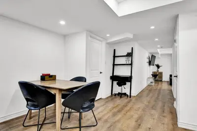 a dining room with a wooden table and chairs at 5mins Shopping, Stylish Modern 2BR Kitchen Suite in Markham in Markham