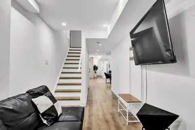 a living room with a couch and a flat screen tv at 5mins Shopping, Stylish Modern 2BR Kitchen Suite in Markham in Markham