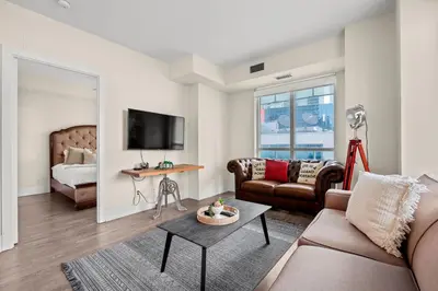 a living room with a couch and a bed at Luxury 2 Bedroom CN Tower View in Toronto