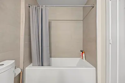 a bathroom with a bath tub with a shower curtain at Luxury 2 Bedroom CN Tower View in Toronto