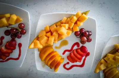 a white plate with fruit on a table at Blue Skies Bed & Breakfast in Niagara on the Lake