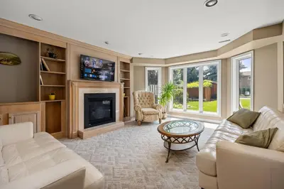 a living room with white furniture and a fireplace at The Wilcox Villa in Mississauga