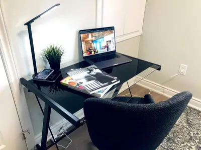 a desk with a laptop computer on it with a chair at Stylish 2bed, 2bth Apt Malls & 25 Mins to Toronto in Mississauga