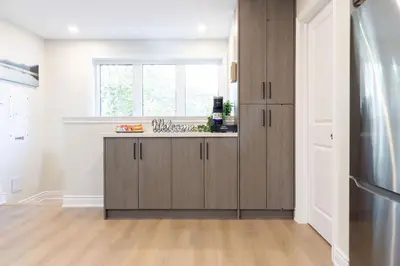 a kitchen with wooden cabinets and a window at Stylish 2bed, 2bth Apt Malls & 25 Mins to Toronto in Mississauga