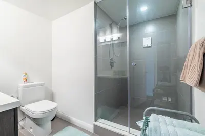 a bathroom with a toilet and a glass shower at Forest 1Bd & DEN in Yorkville 10 Floor in Toronto