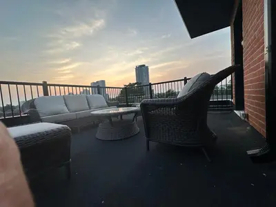 a balcony with a couch and a table and chairs at Mins from Toronto Downtown UFT Exhibition Place in Toronto