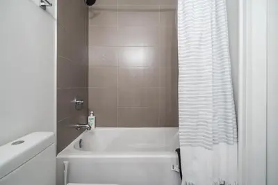 a bathroom with a tub and a white shower curtain at Gorgeous 1 Bedroom Apt with Balcony in Yorkville in Toronto
