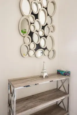 a mirror hanging on a wall above a wooden table at Gorgeous 1 Bedroom Apt with Balcony in Yorkville in Toronto