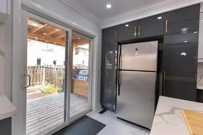 a kitchen with black cabinets and a stainless steel refrigerator at Greate place with lot of rooms for relaxing in Toronto