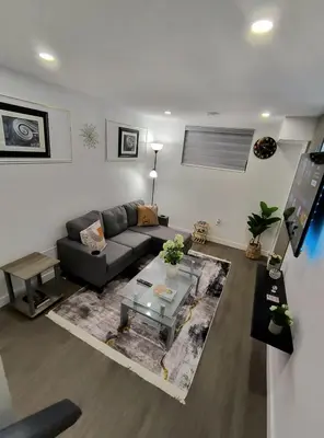 a living room with a couch and a table at ArbyManie's Place Newly Built Basement Apartment in London