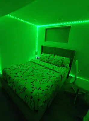 a green bedroom with a bed with a green light at ArbyManie's Place Newly Built Basement Apartment in London