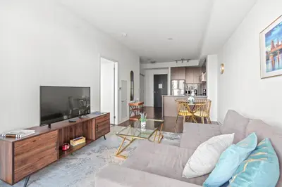 a living room with a couch and a flat screen tv at Cozy 1 Bedroom Dunfield Ave in Toronto