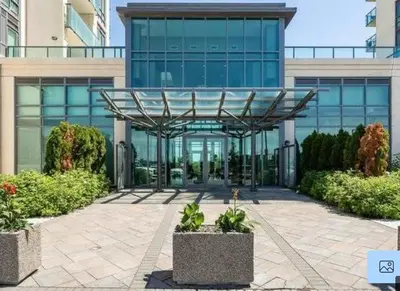 a building with a glass facade with plants in front of it at Aseesniwas in Brampton