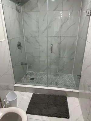 a shower with a glass door in a bathroom at Cozy 1 Bedroom Apartment in Brampton