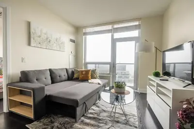 a living room with a couch and a large window at Modern 1 BR Apartment in North York Free parking in Toronto