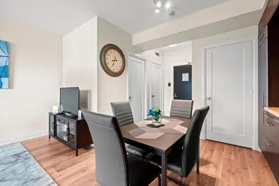 a dining room with a table and chairs and a clock at Amazing 1Bedroom 1BR Sheppard Metro Free parking in Toronto