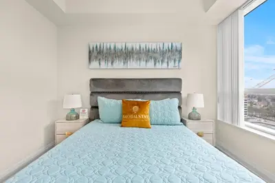 a bedroom with a blue bed with two windows at Amazing 1Bedroom 1BR Sheppard Metro Free parking in Toronto