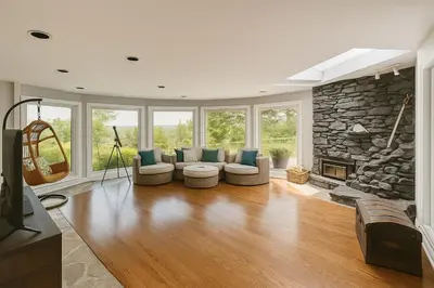 a living room with couches and a stone fireplace at Fieldstone & Sky in Frankford