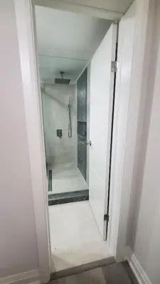 a walk in shower in a white bathroom with a shower stall at Cozy Basement Stay in Mississauga in Mississauga