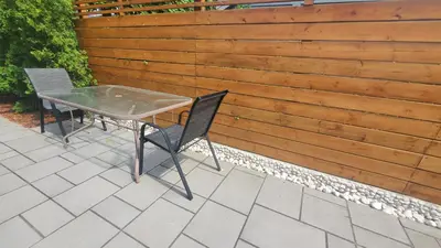 a table and chairs on a patio with a fence at Cozy Basement Stay in Mississauga in Mississauga