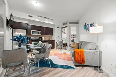 a living room and kitchen with a couch and a table at Superior 1Bd & DEN Apartment with Balcony in Toronto